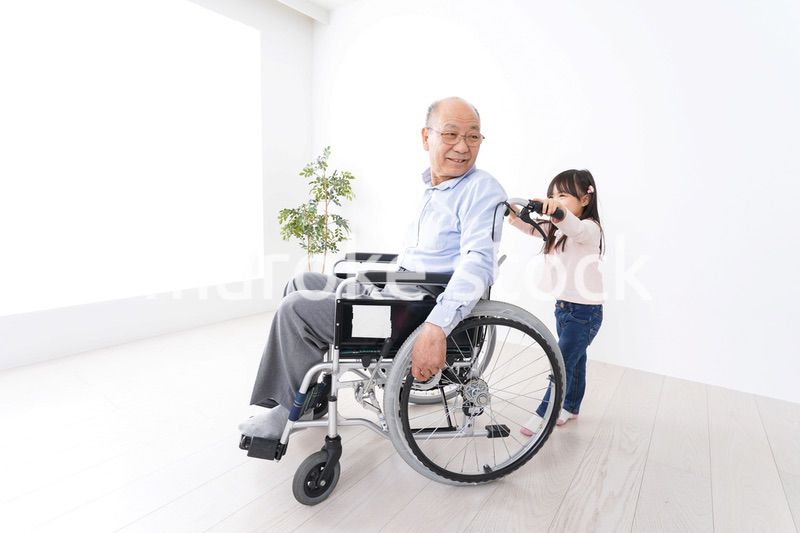 車椅子に乗る高齢男性と女の子