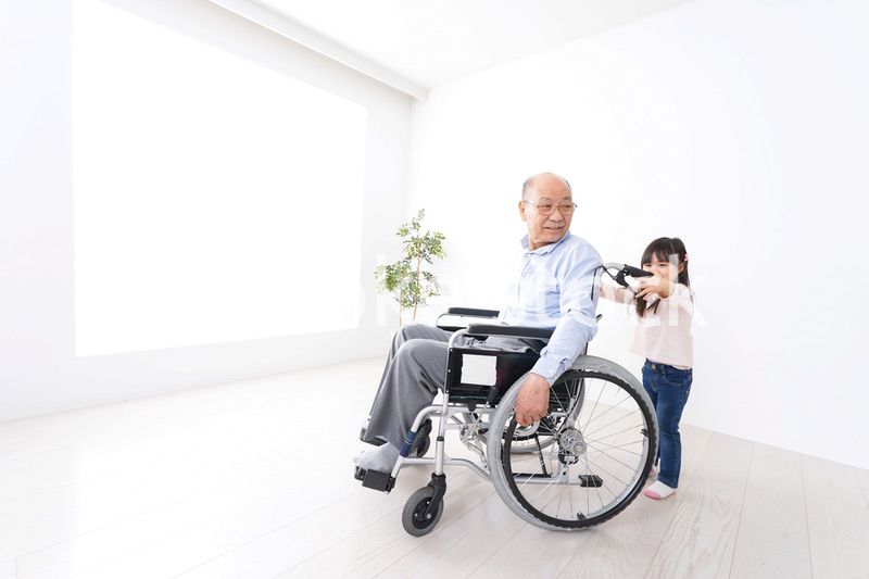 車椅子に乗る高齢男性と女の子