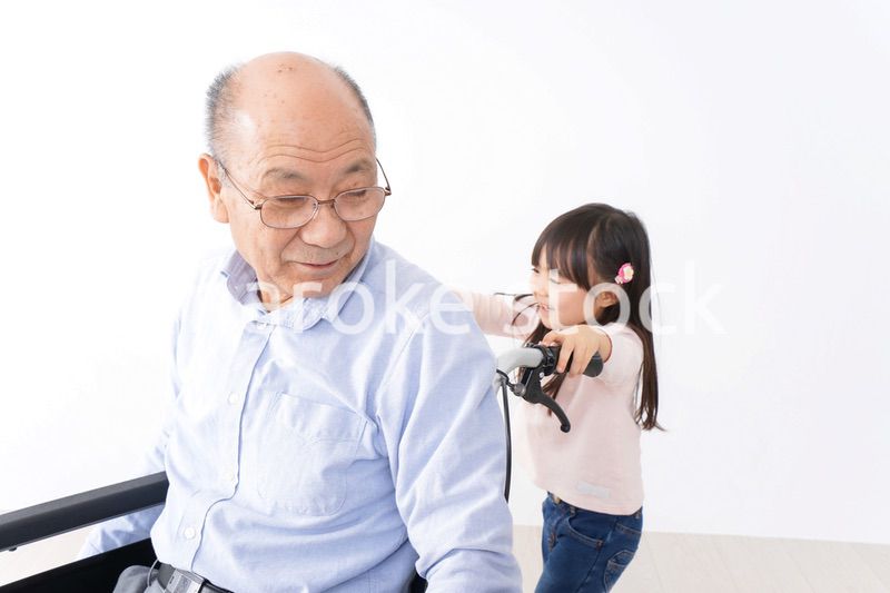 車椅子に乗る高齢男性と女の子