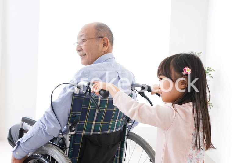 車椅子に乗る高齢男性と女の子