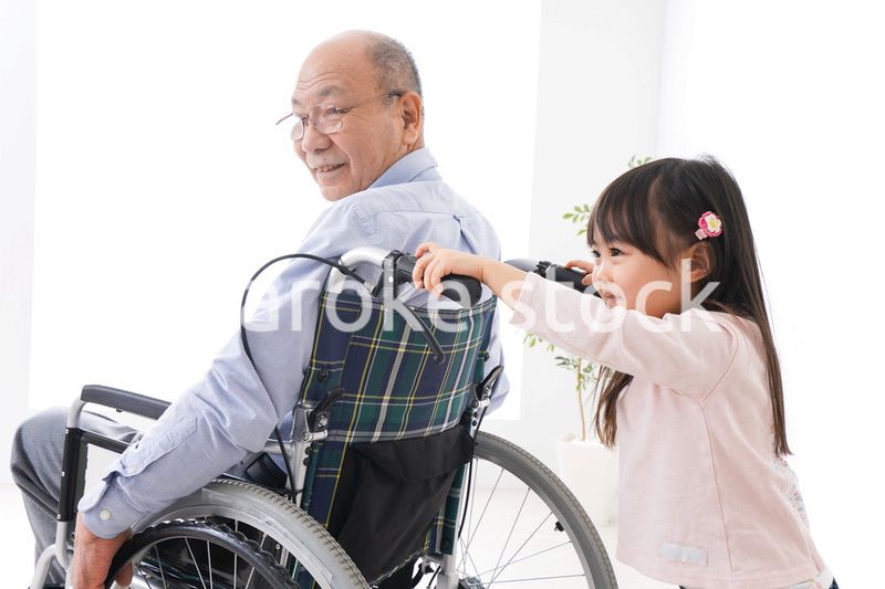 車椅子に乗る高齢男性と女の子