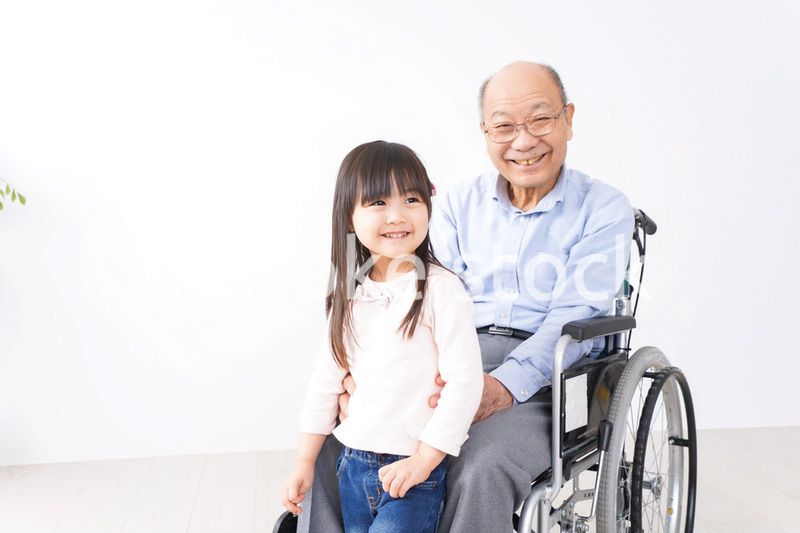 車椅子に乗る高齢男性と女の子