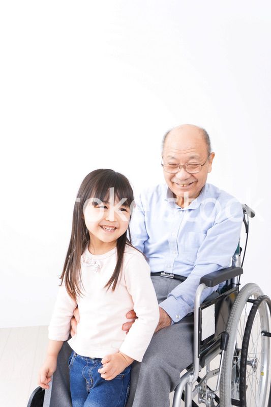 車椅子に乗る高齢男性と女の子