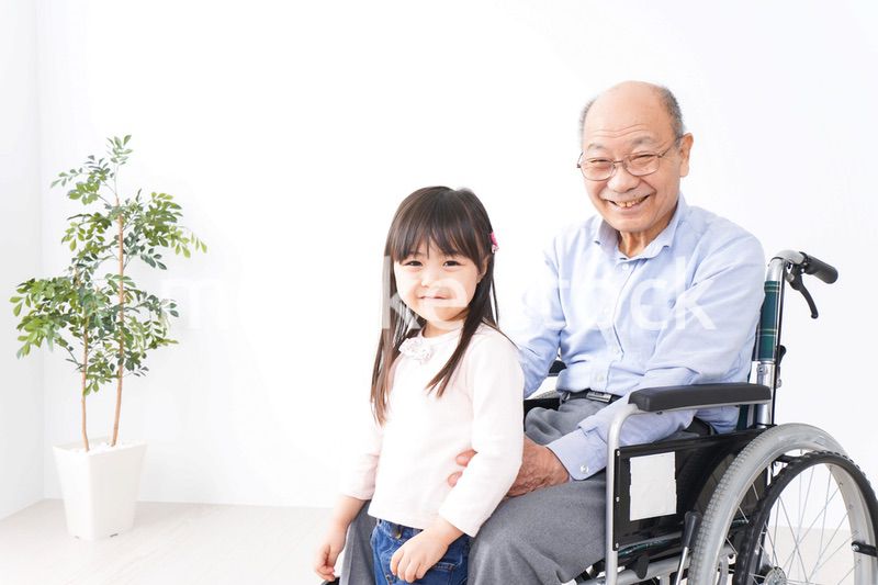 車椅子に乗る高齢男性と女の子