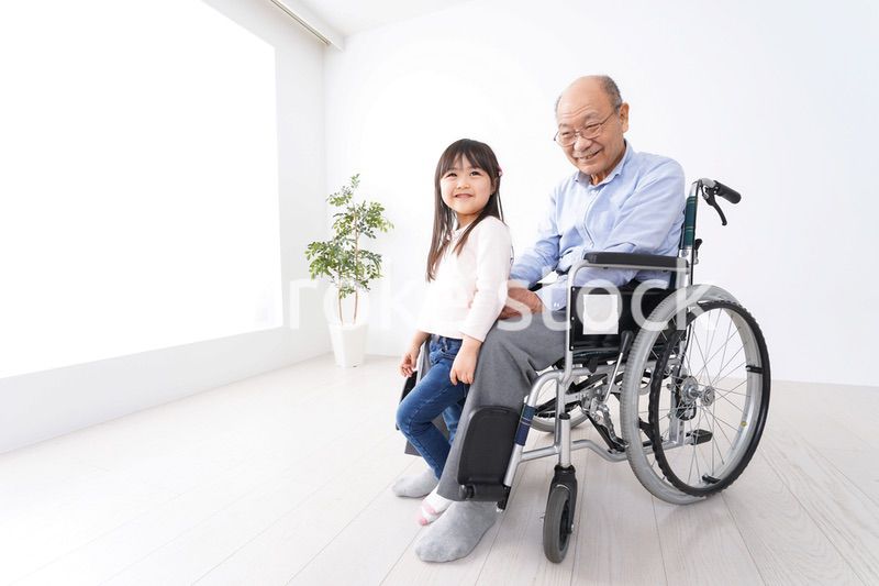 車椅子に乗る高齢男性と女の子