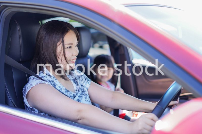 お母さんと車に乗る小さな女の子
