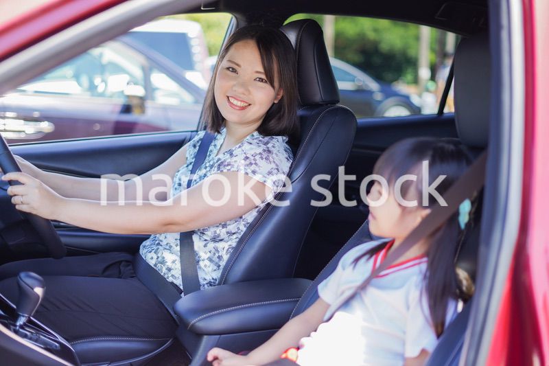 お母さんと車に乗る小さな女の子
