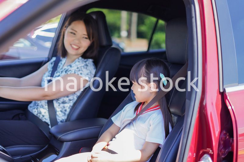 お母さんと車に乗る小さな女の子