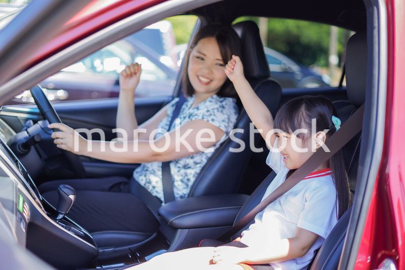 お母さんと車に乗る小さな女の子