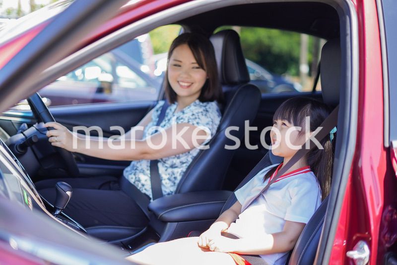 お母さんと車に乗る小さな女の子