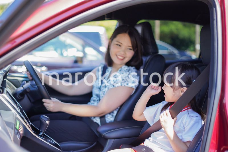 お母さんと車に乗る小さな女の子