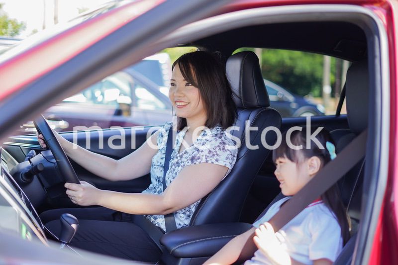 お母さんと車に乗る小さな女の子