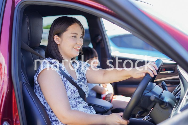 お母さんと車に乗る小さな女の子