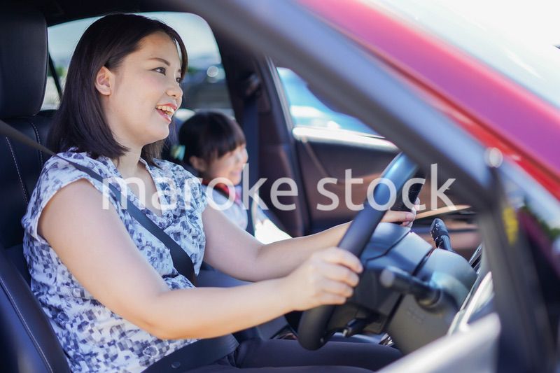 お母さんと車に乗る小さな女の子