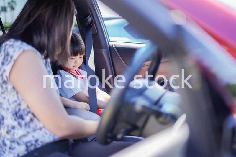 お母さんと車に乗る小さな女の子