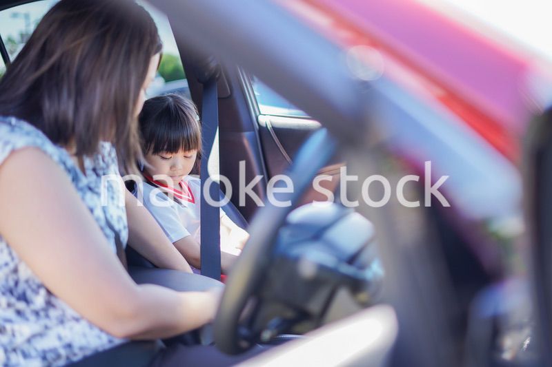 お母さんと車に乗る小さな女の子