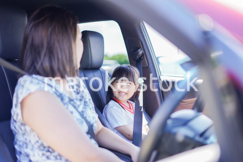 お母さんと車に乗る小さな女の子