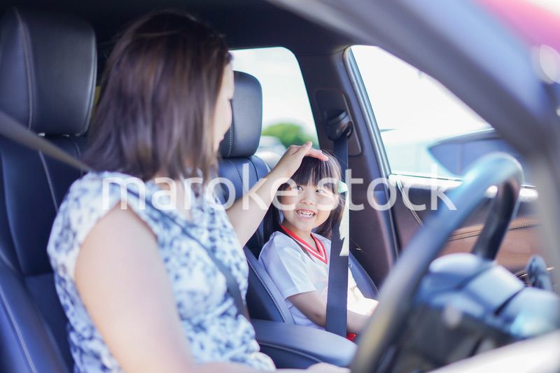 お母さんと車に乗る小さな女の子