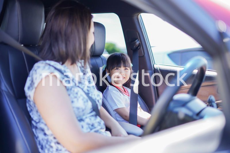 お母さんと車に乗る小さな女の子