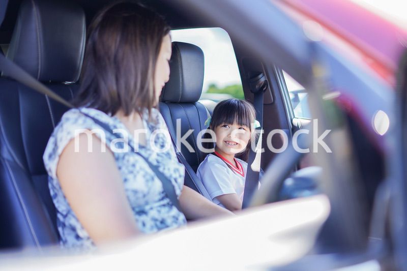お母さんと車に乗る小さな女の子