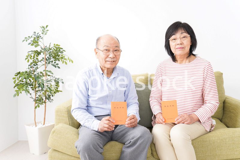 年金手帳を持つ高齢の夫婦