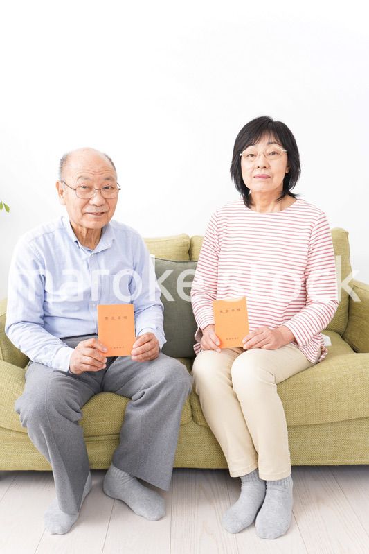 年金手帳を持つ高齢の夫婦