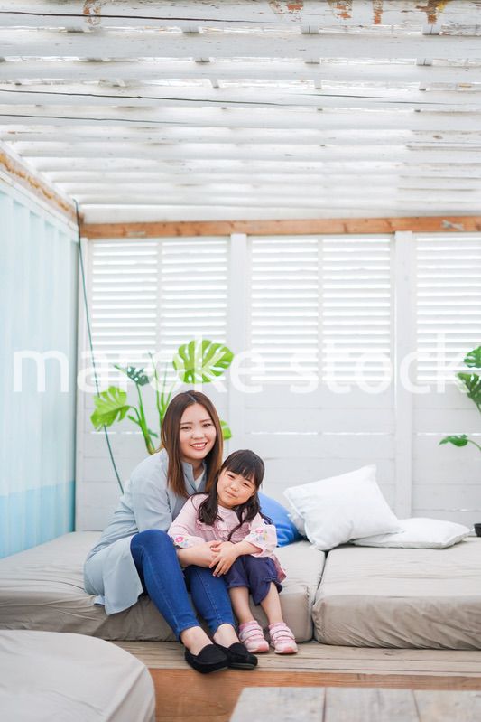 お昼寝をする小学生の女の子とお母さん