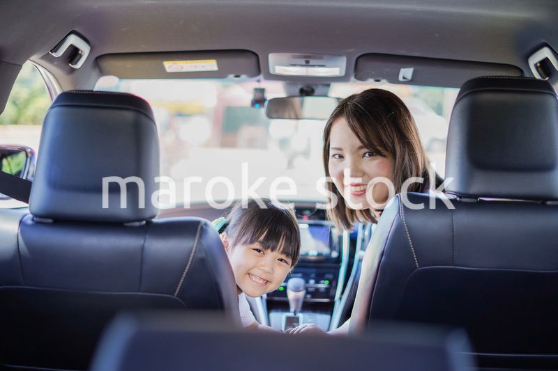 お母さんと車に乗る小さな女の子