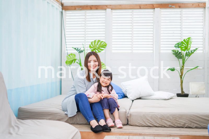 お昼寝をする小学生の女の子とお母さん