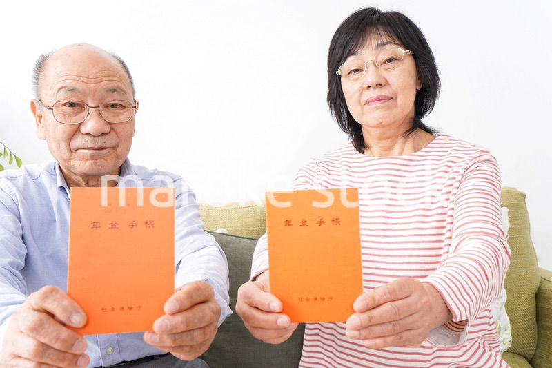 年金手帳を持つ高齢の夫婦