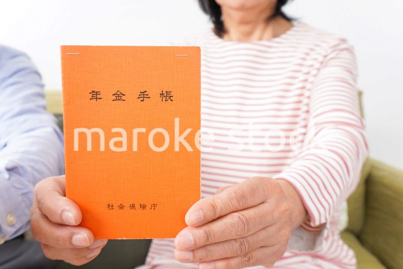 年金手帳を持つ高齢の夫婦
