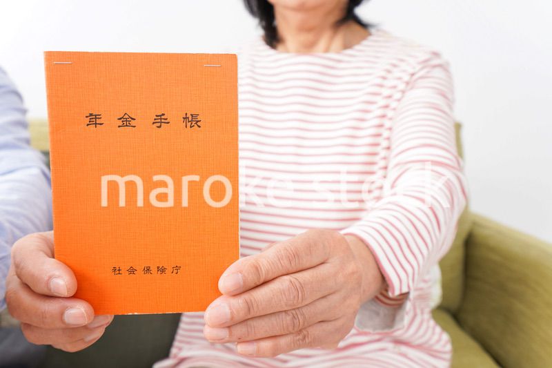 年金手帳を持つ高齢の夫婦