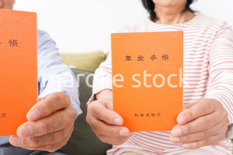 年金手帳を持つ高齢の夫婦
