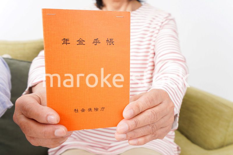 年金手帳を持つ高齢の夫婦