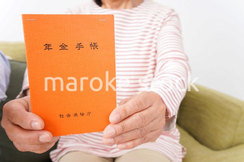 年金手帳を持つ高齢の夫婦