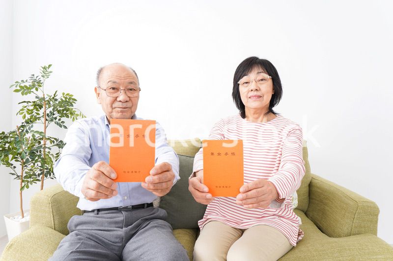 年金手帳を持つ高齢の夫婦