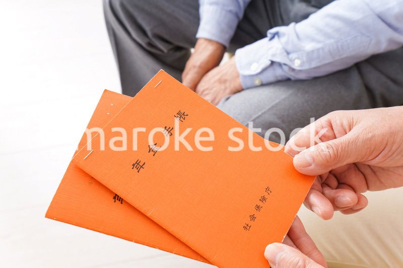 年金手帳を持つ高齢の夫婦