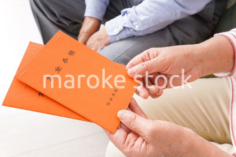 年金手帳を持つ高齢の夫婦