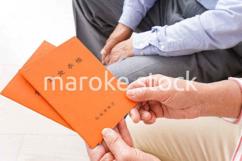 年金手帳を持つ高齢の夫婦