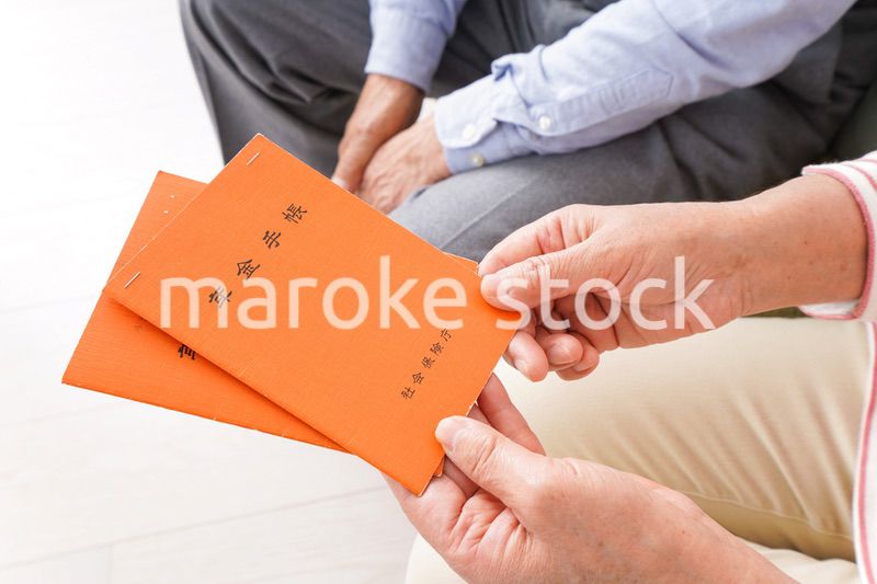 年金手帳を持つ高齢の夫婦