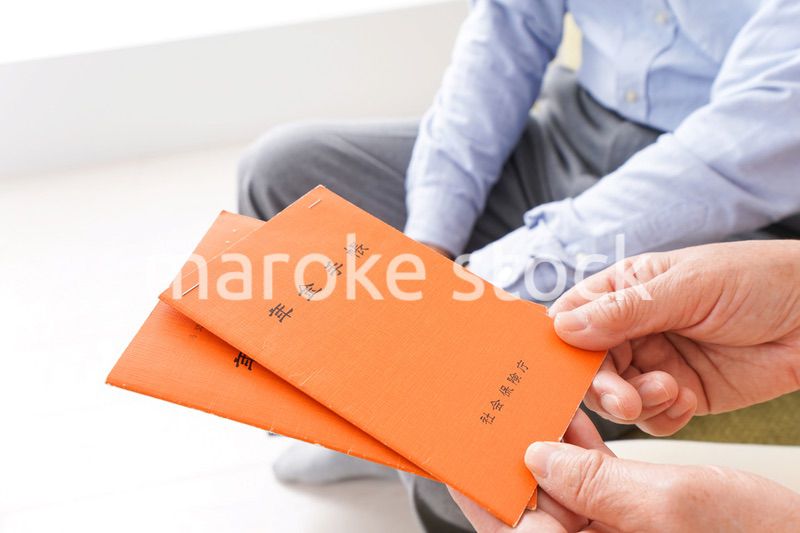 年金手帳を持つ高齢の夫婦