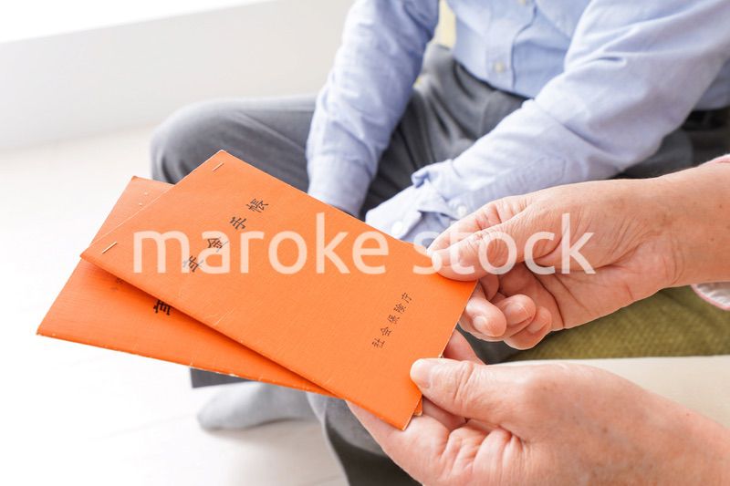 年金手帳を持つ高齢の夫婦