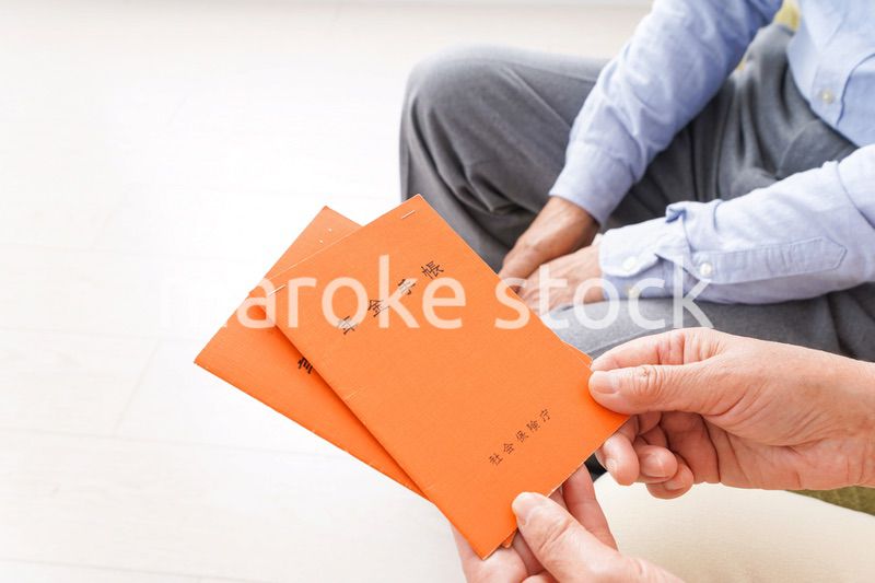 年金手帳を持つ高齢の夫婦