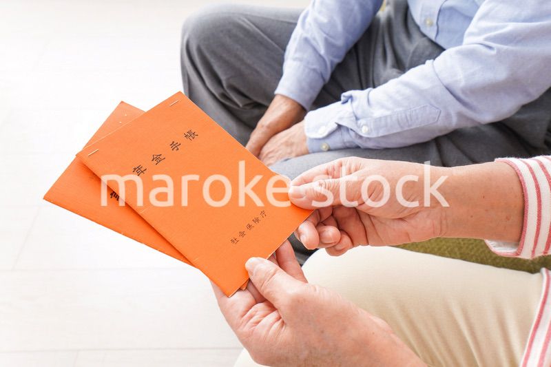 年金手帳を持つ高齢の夫婦