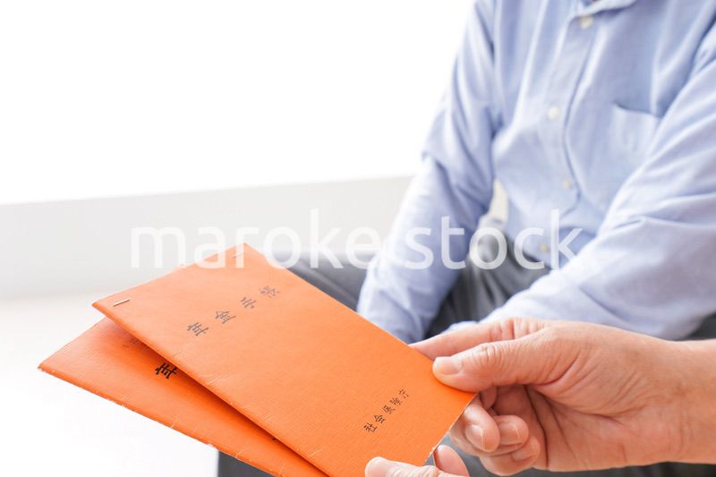 年金手帳を持つ高齢の夫婦