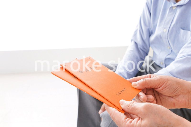 年金手帳を持つ高齢の夫婦