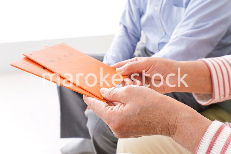 年金手帳を持つ高齢の夫婦