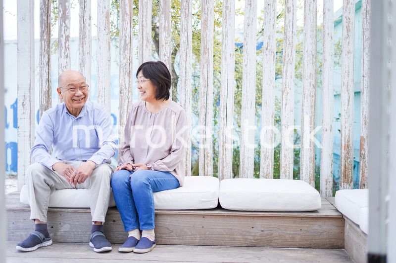 リゾート地で仲良く会話をする高齢の夫婦