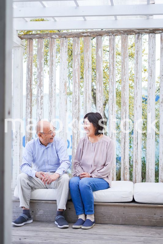 リゾート地で仲良く会話をする高齢の夫婦