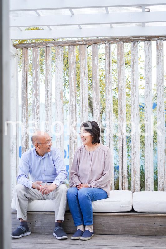 リゾート地で仲良く会話をする高齢の夫婦